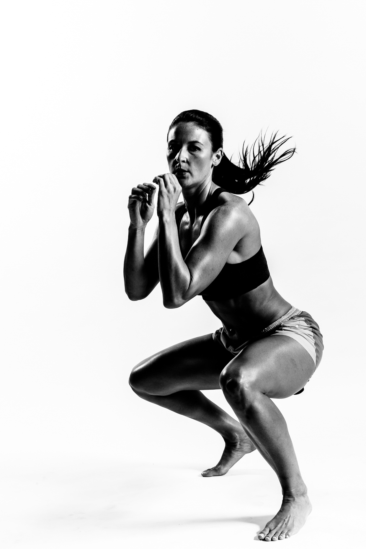 Female B&W martial arts instructor in fighing squat stance by andy batt