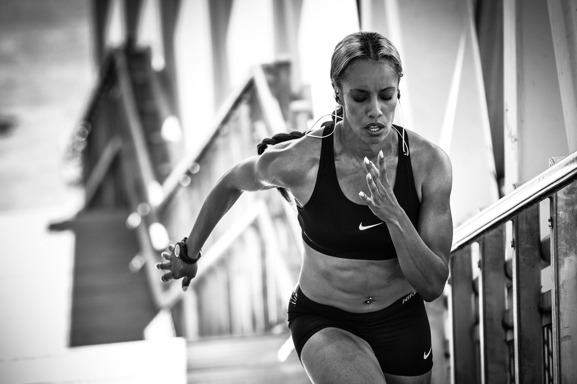 B&W image of Olympic track athlete Carol Rodriguez running up stairs along the Portland Esplanade by Andy Batt for Monster iSport