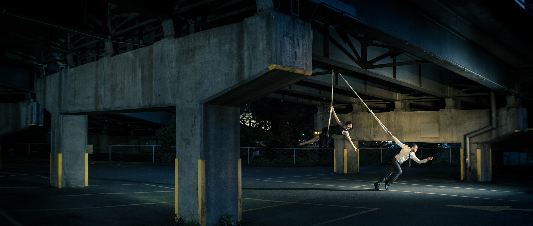 In this scene, Modern dancers Noel Plemons and Rachael Lembo practice social distance in this award-winning image under Morrison Bridge. Rachael is suspended by a rope and Noel keeps the tension on the the opposite end of the rope by Andy Batt