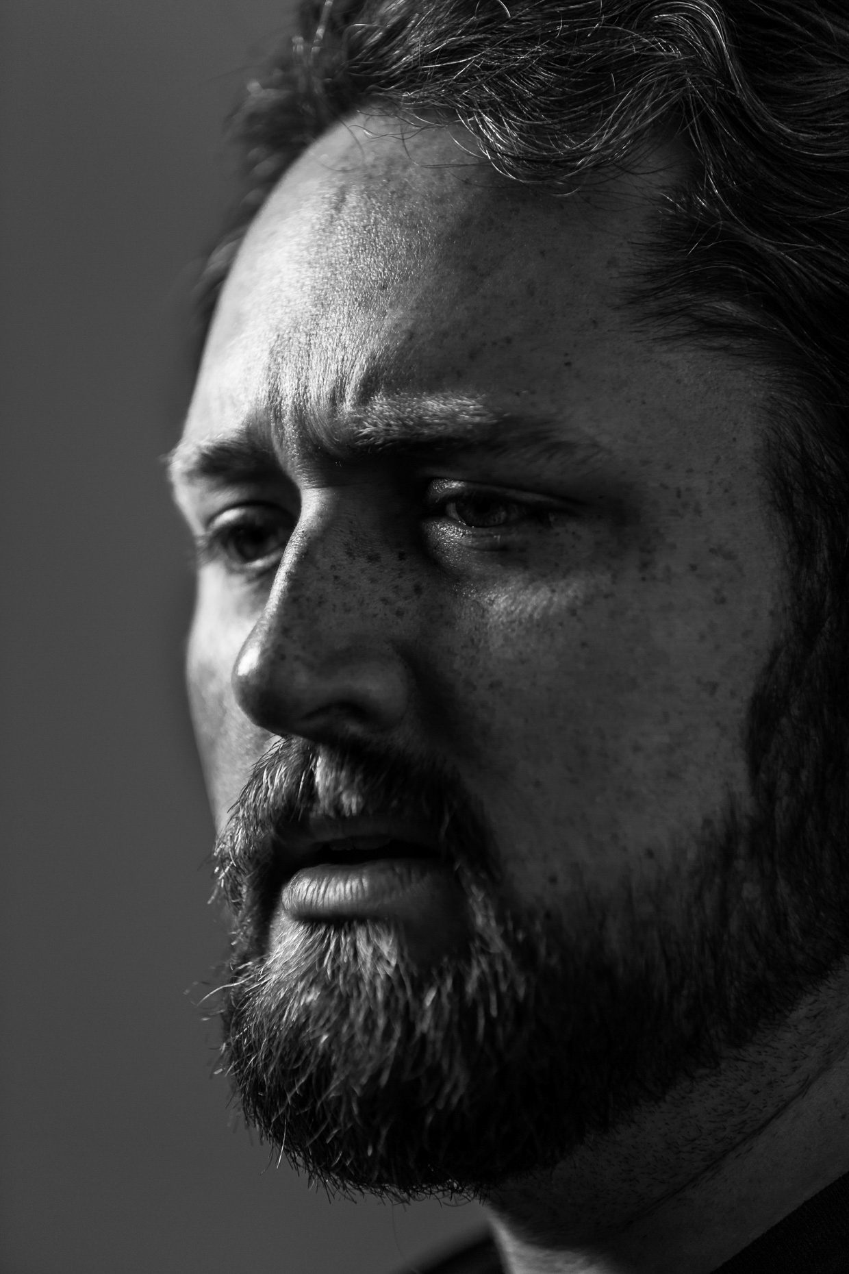 Tight B&W editorial portrait of maker Galvin Collins leather laser wood artist. Photo by Andy Batt