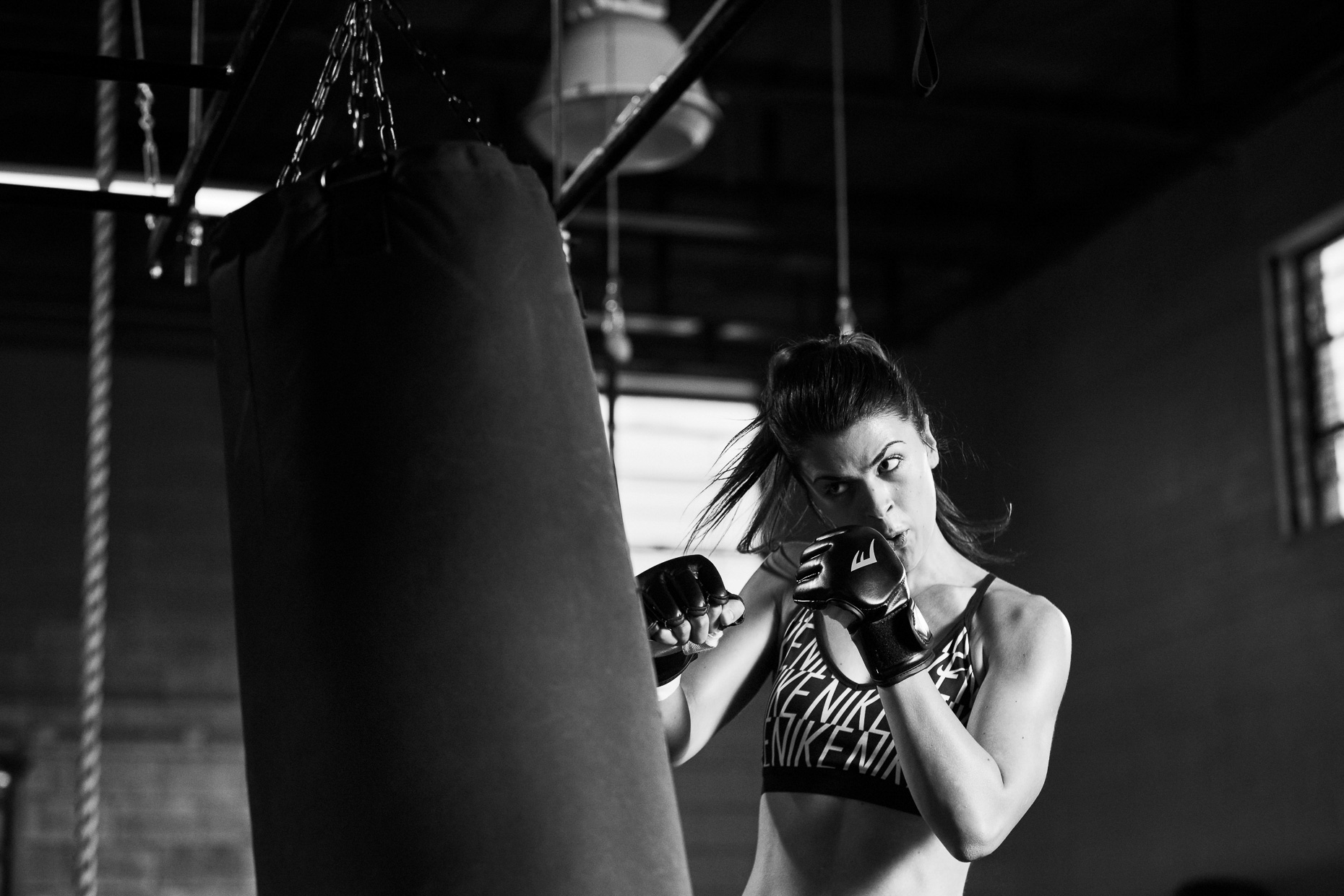 Crossfit boxing Hibbett Sports with Victoria Petrosky as she punches a heavy bag while training in a gym in Birmingham Alabama by Andy Batt