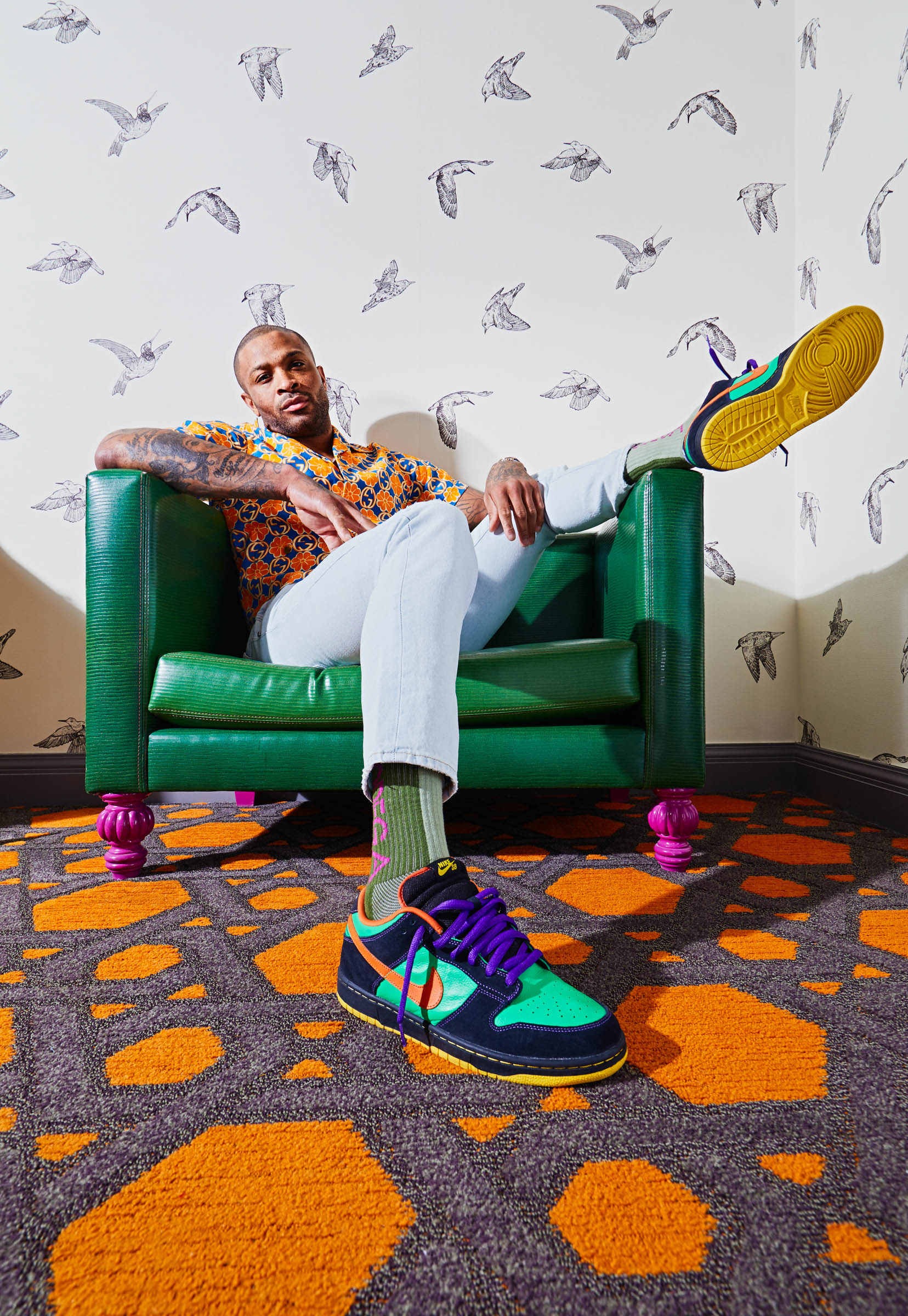 Portrait of P.J. Tucker sitting in a too-small chair. He is the NBA’s sneaker king, and a forward on the Houston Rockets. Photographed at the Monaco Hotel for Footwear News by Andy Batt.
