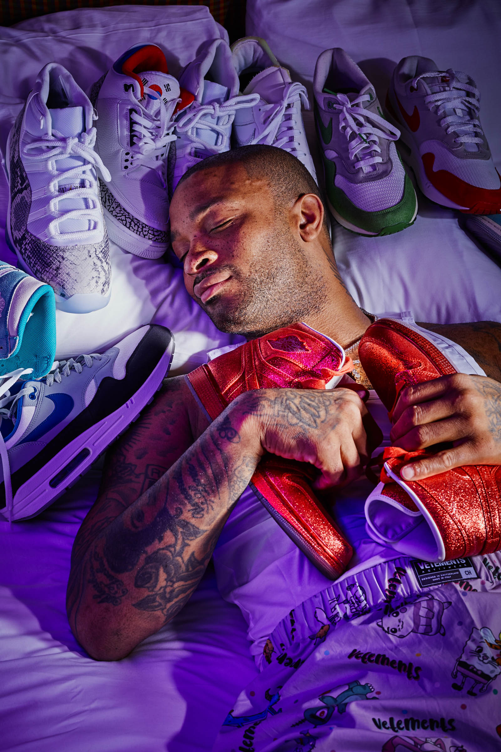 P.J. Tucker is the NBA’s sneaker king, and a forward on the Houston Rockets. Photographed sleeping in bed at the Monaco Hotel, snuggling his collection of collectible sneakers for Footwear News Magazine by Andy Batt.