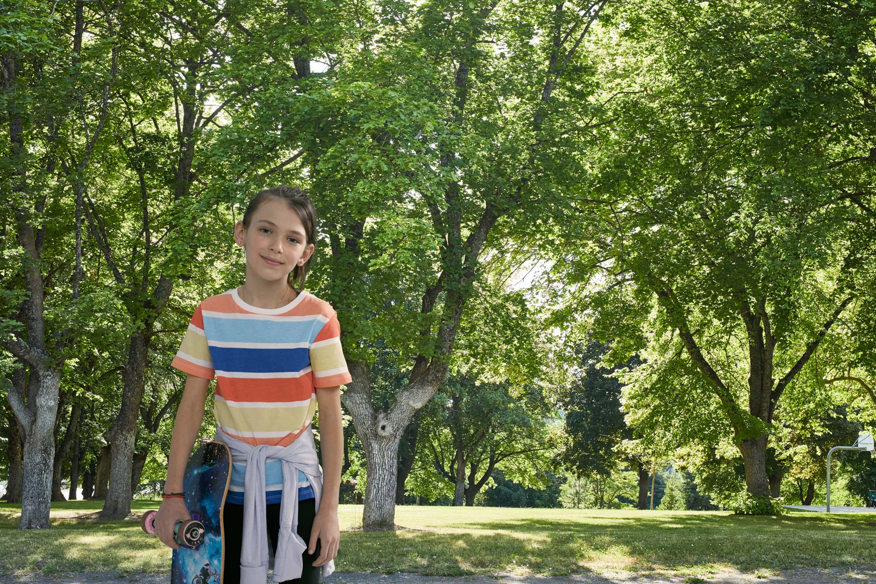 Little girl with skateboard in park