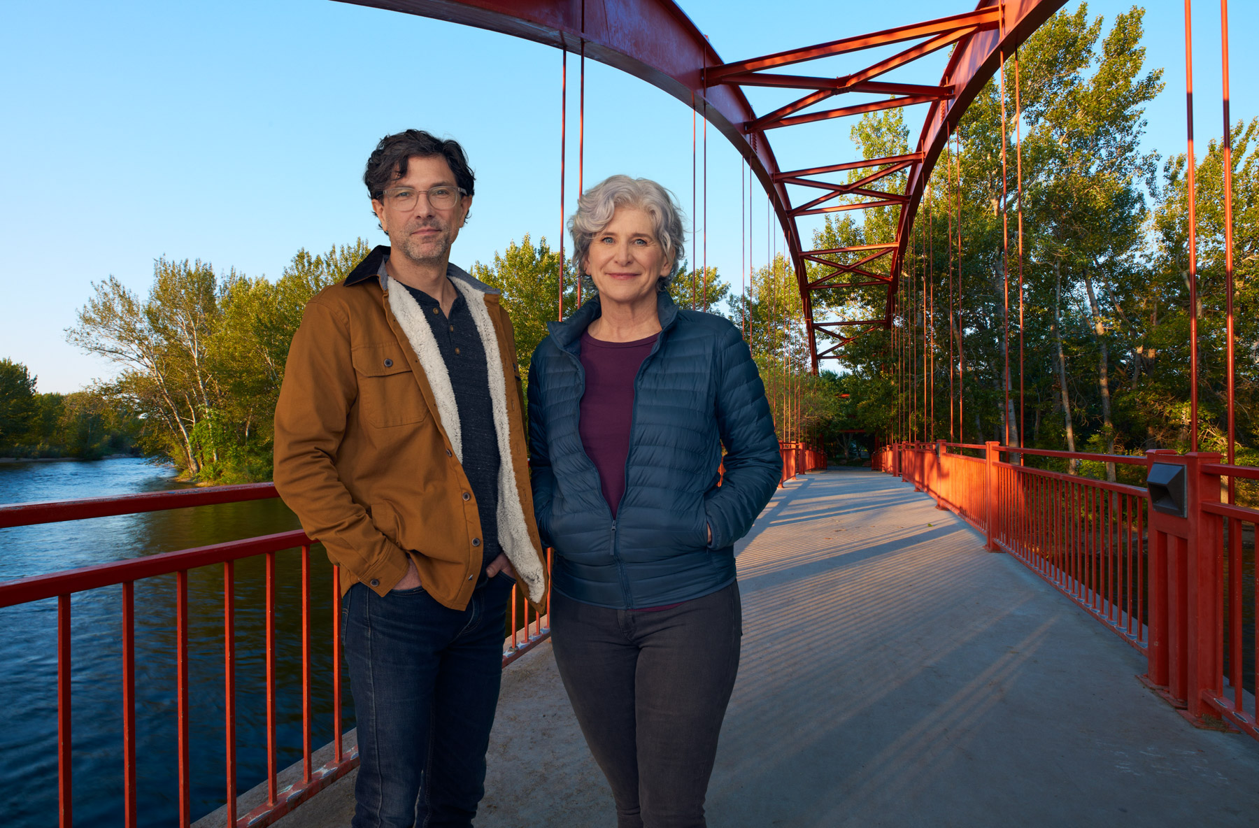 Couple poses at red pedestrian bridge in Boise, Idaho