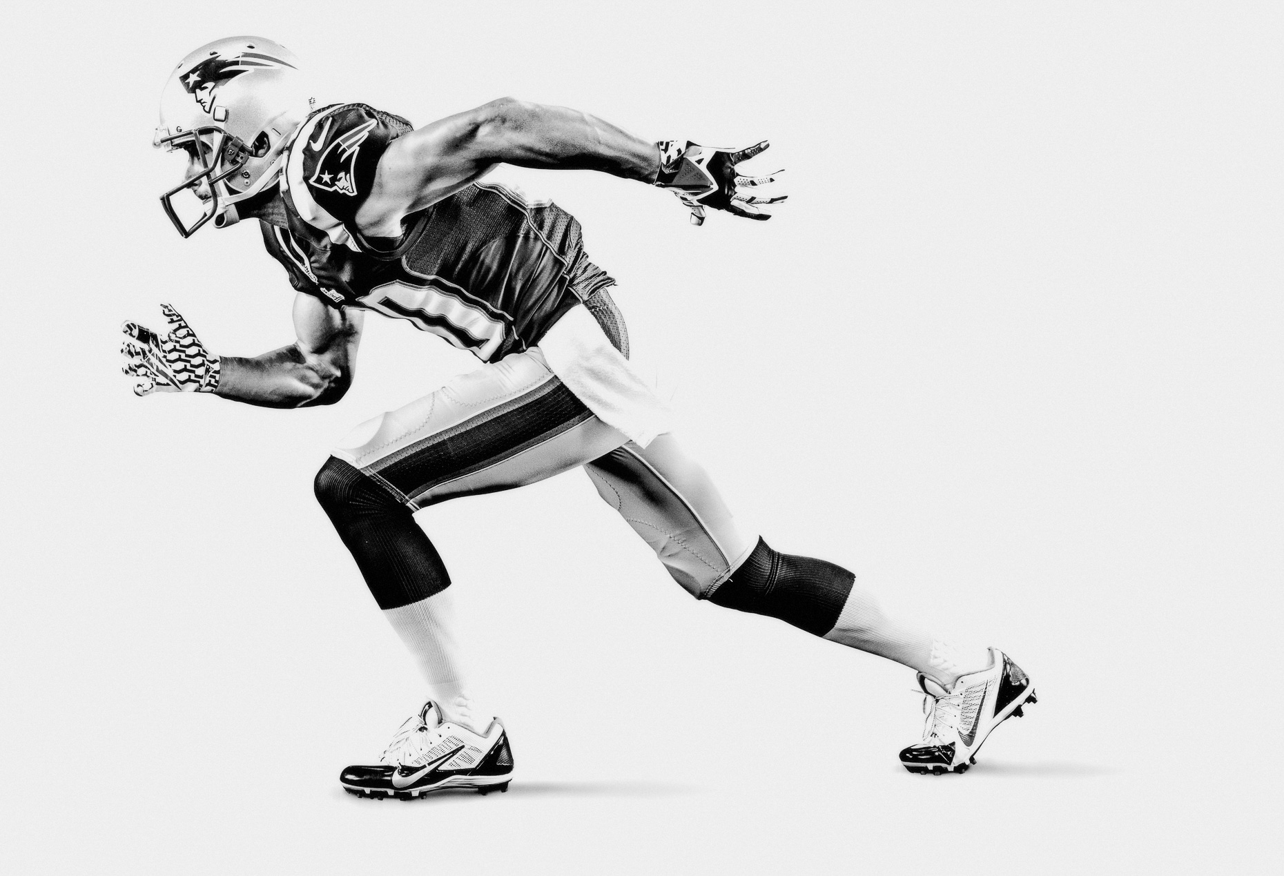 NFL Verizon Danny Amendola New England Patriots football in a white studio B&W in a running pose by Andy Batt
